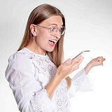 Frau schaut freudig aufs Smartphone